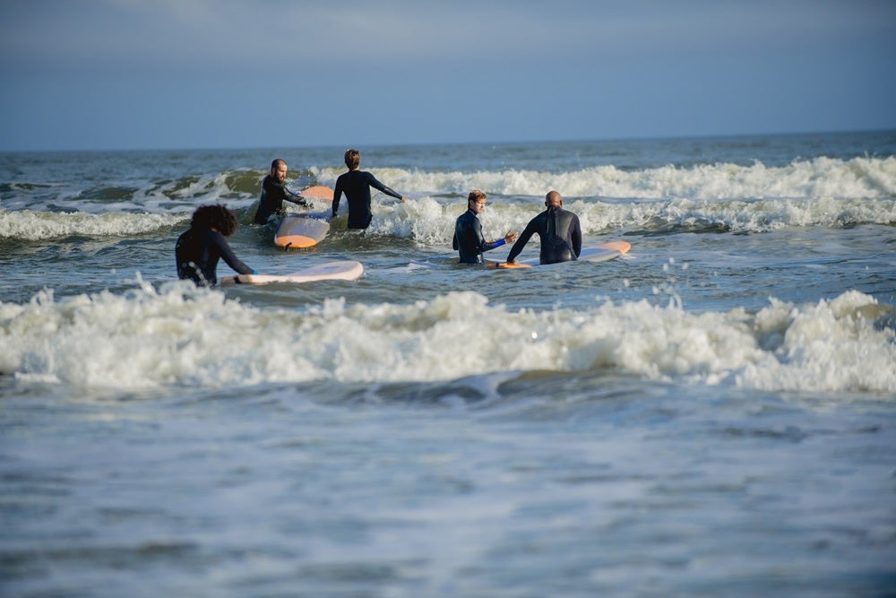 photo of group of surfers in the water
