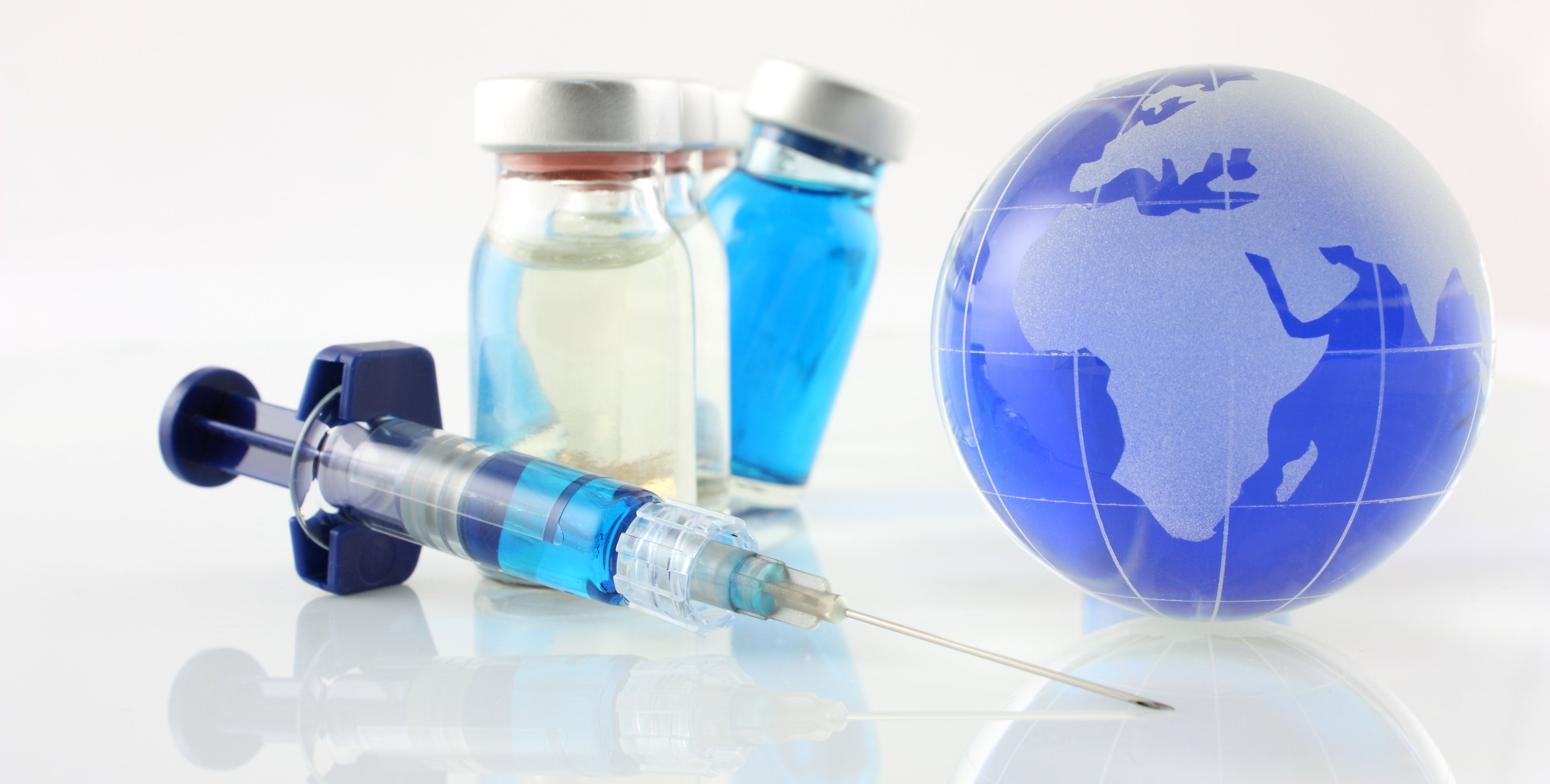 A needle, three vials of medicine and a small blue globe