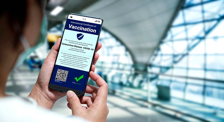 Traveler holds vaccine passport certificate to show COVID 19 vaccination status