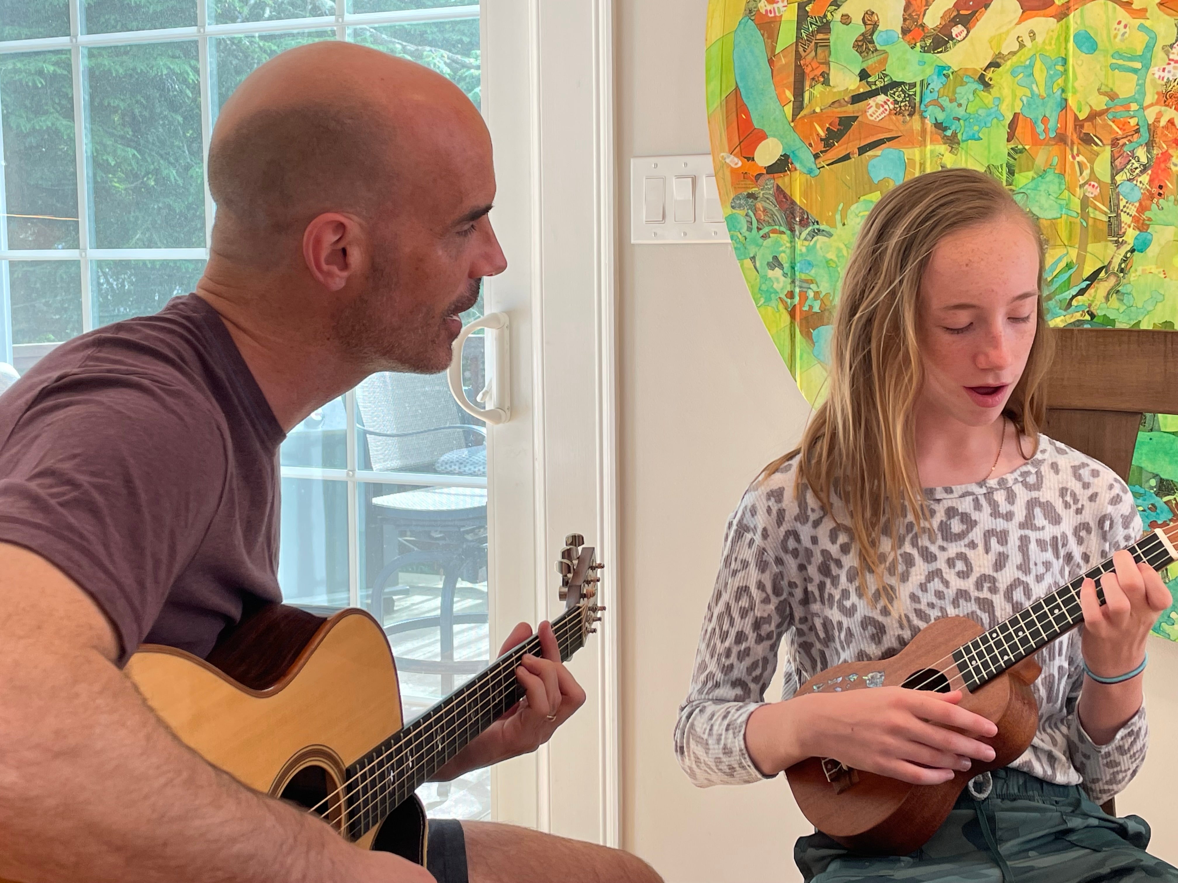 Joseph Allen playing guitar with his daughter.