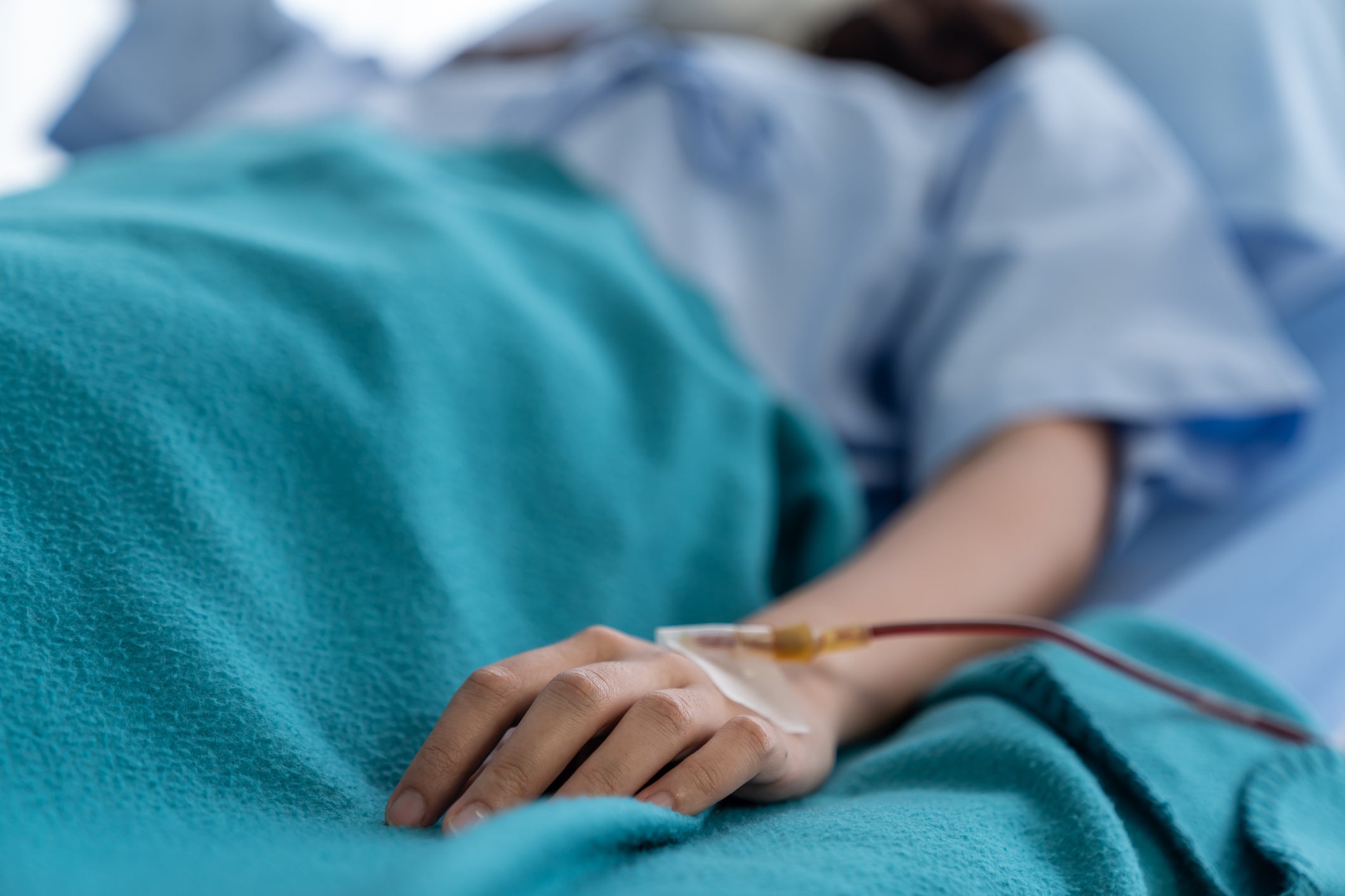 Close up of hand/arm of a woman patient laying in a hospital bed.