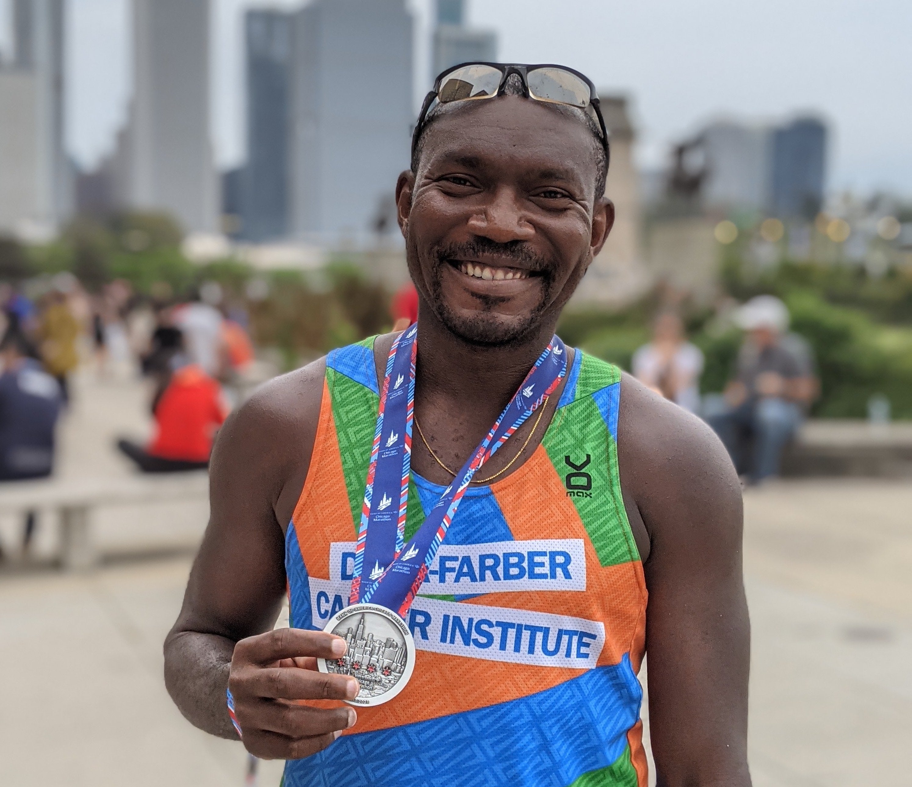 Temidayo Fadelu holding his medal after finishing a marathon.