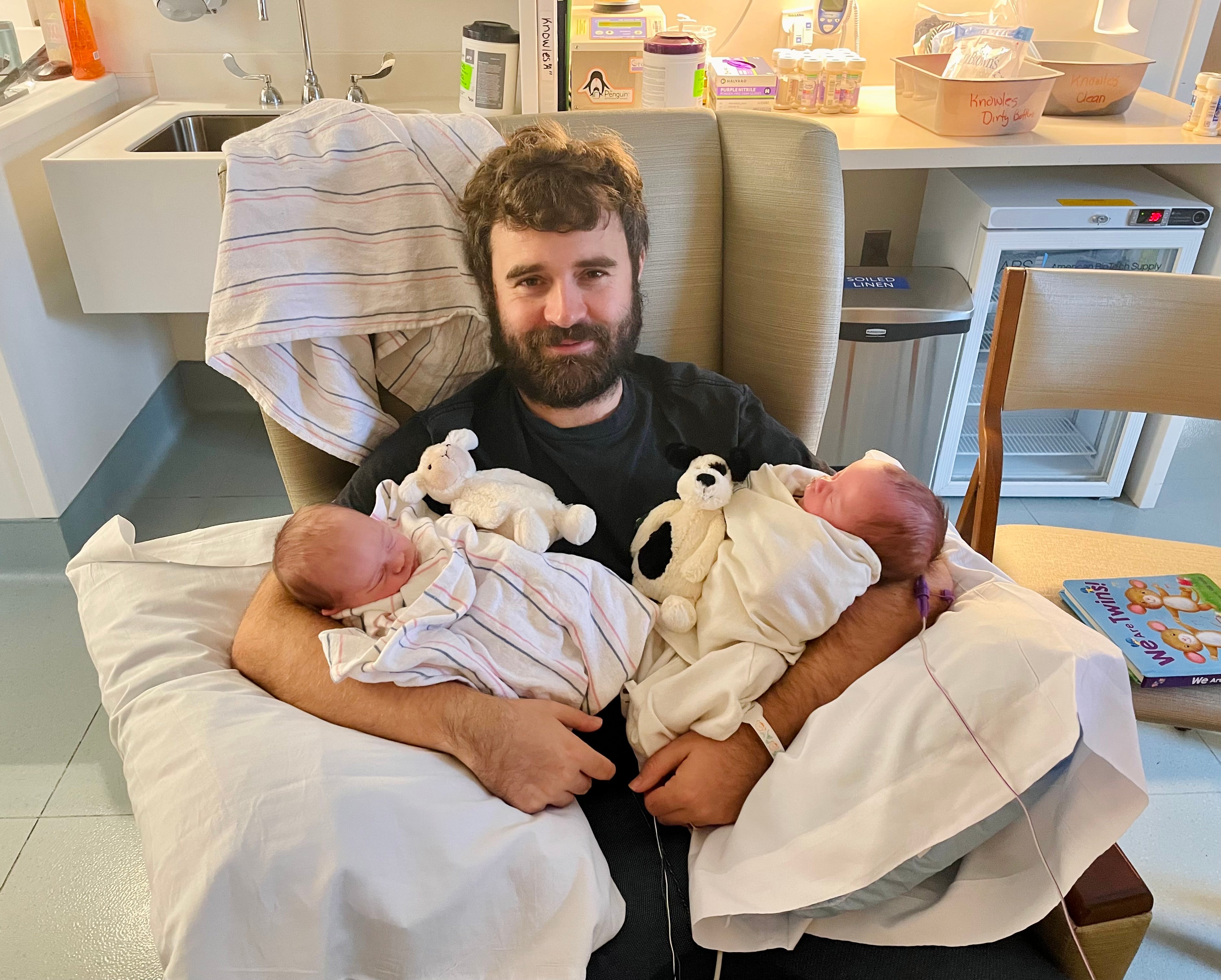 Sameul Mathias holding his newborn twins.