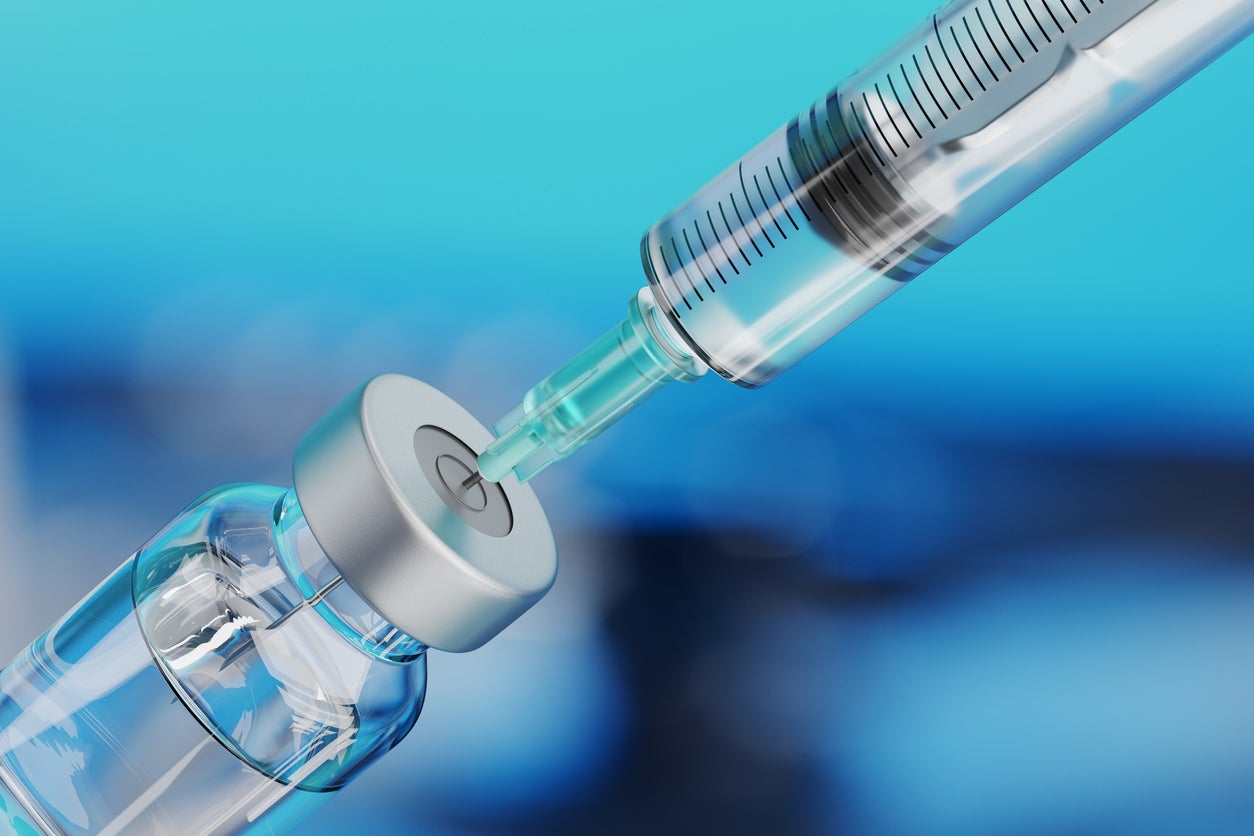 Close up of a medical disposable syringe and glass vial.