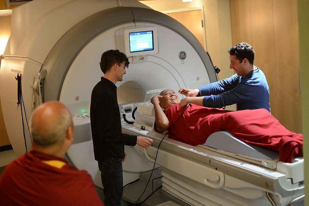 Matthew Sacchet at brain scanner with a Tibetan monk.