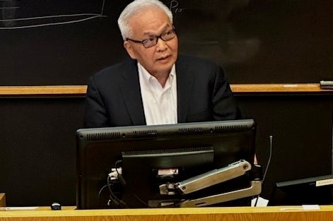 LJ Wei at a podium giving a presentation.