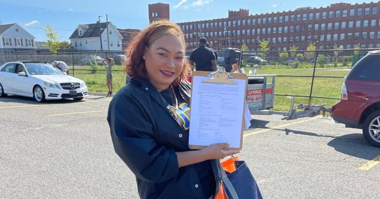 Chrismery Gonzalez holding a clipboard with a survey.