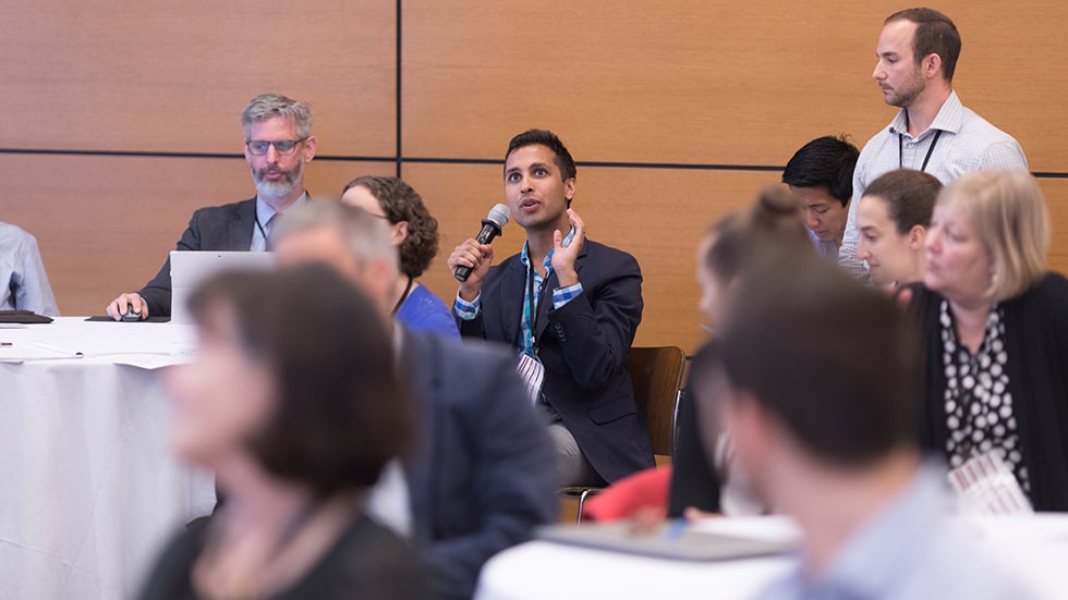 Ankur Pandya speaking into a microphone at a conference.